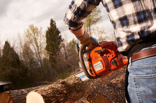 man holding orange chainsaw