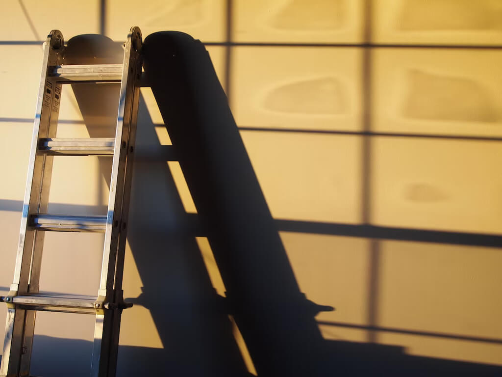 aluminum ladder leaning against wall