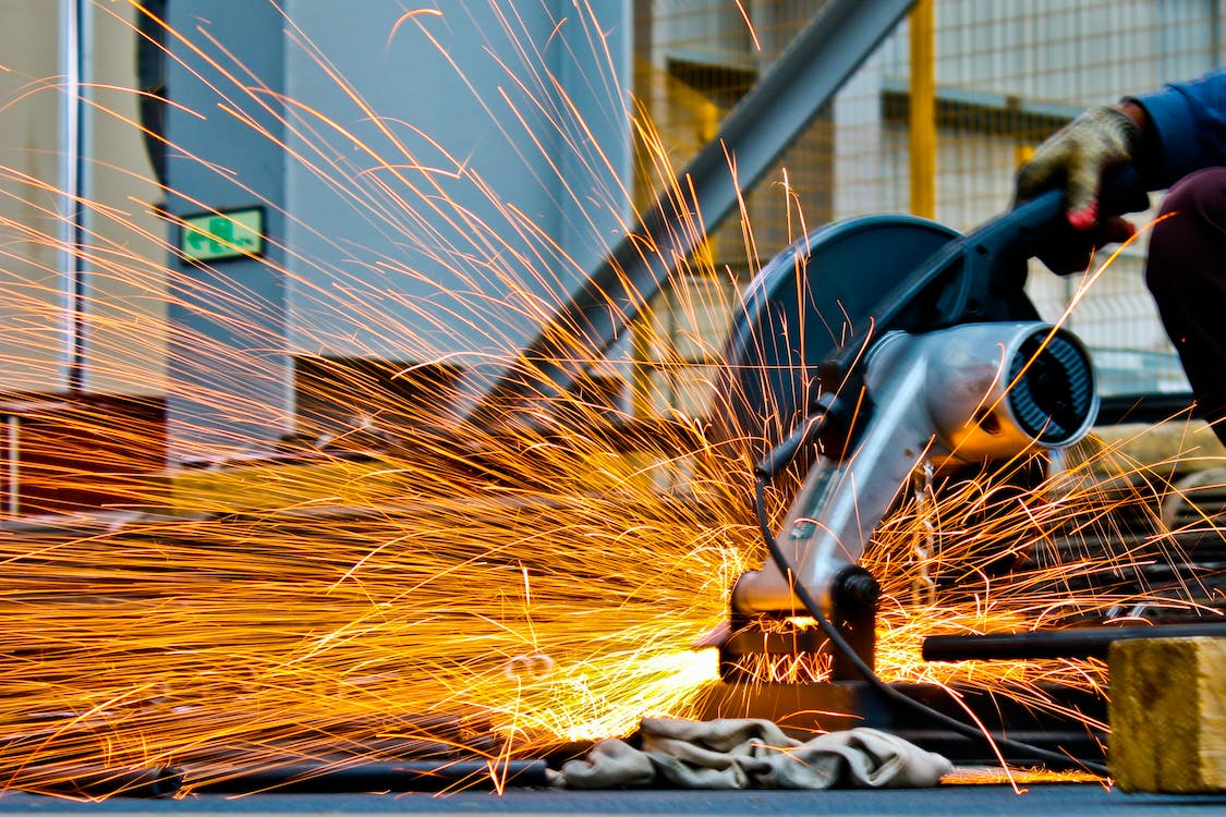 saw cutting piece of metal with sparks flying