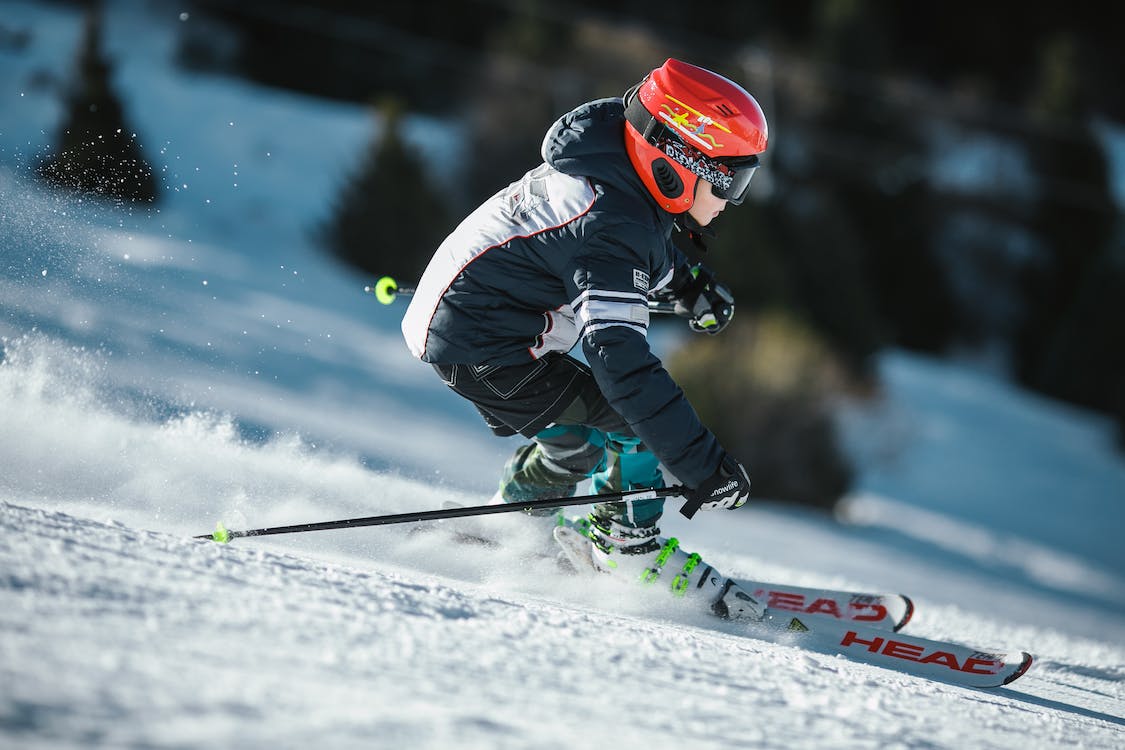 skier in red helmet gliding downhill